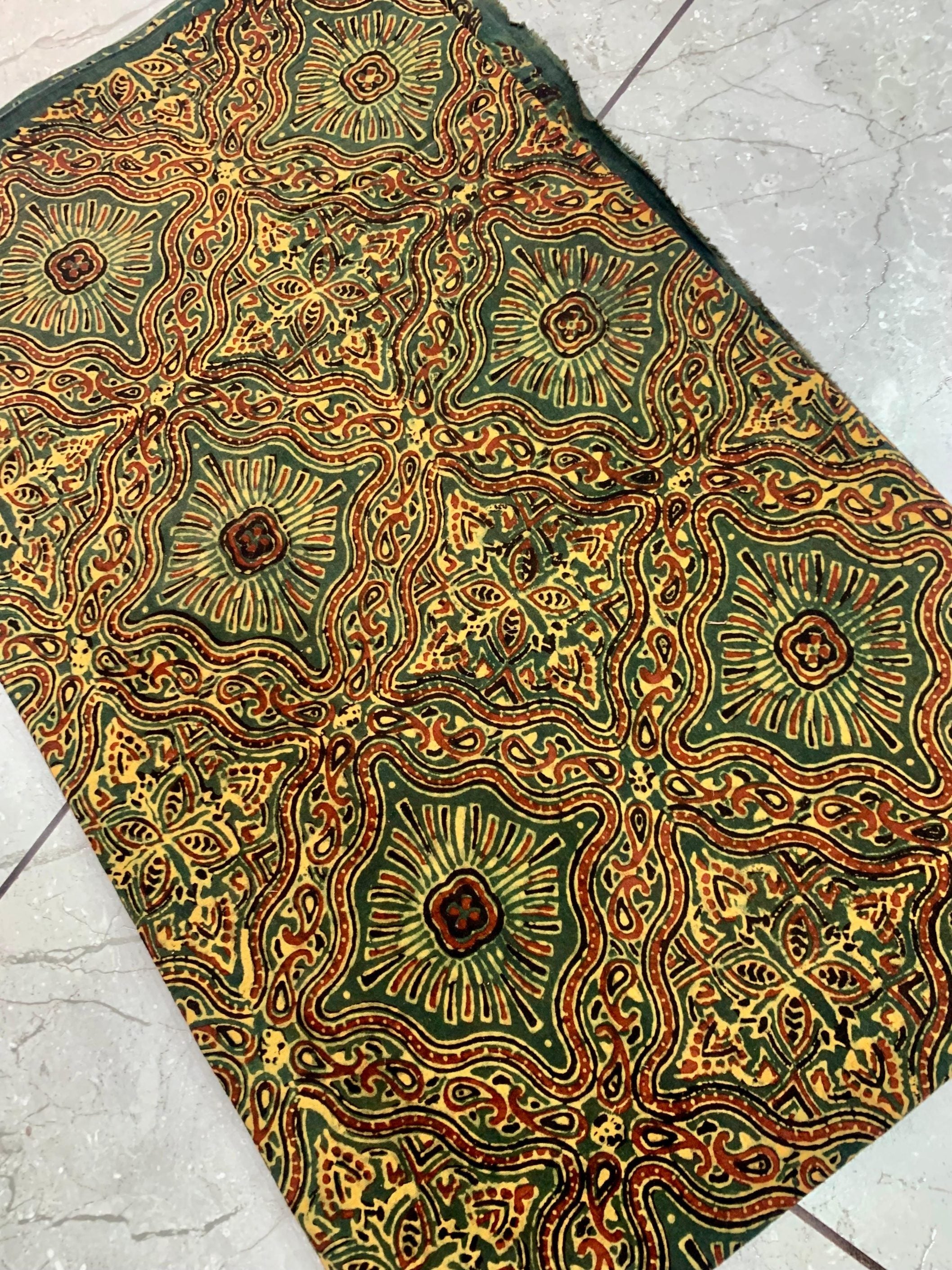 Green Jaal Ajrakh pure cotton wholesale fabric showcasing dense block-printed lattice designs in natural dyes.